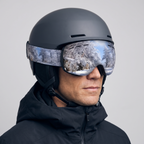 Man wearing the ski goggles over a helmet, three-quarter side view