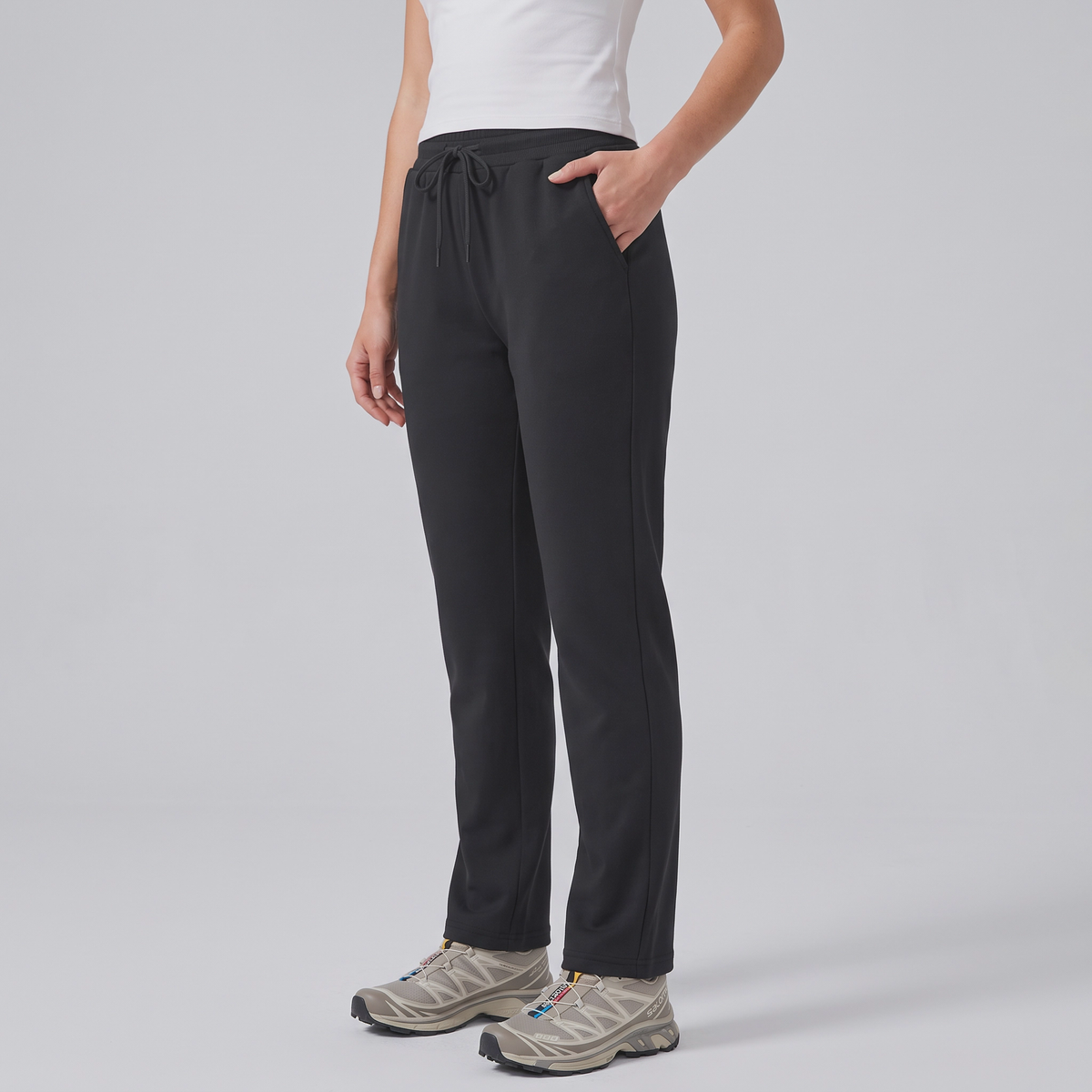 Three-quarter side view of the black fleece lined joggers worn, hand in the side pocket