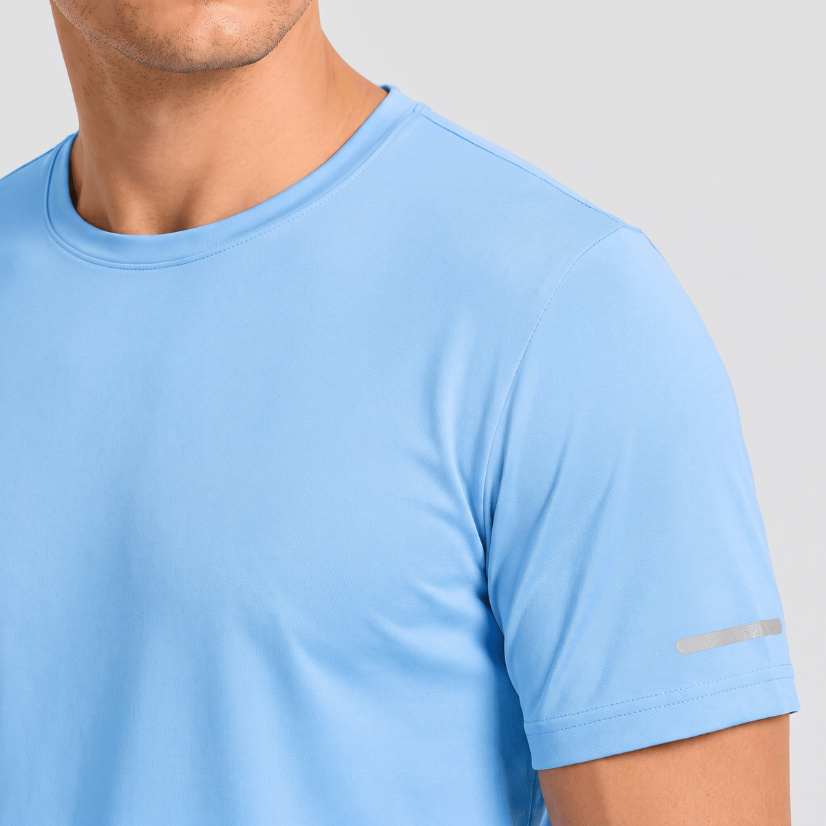 Close-up of the crew neck and reflective sleeve strip on the men's running top
