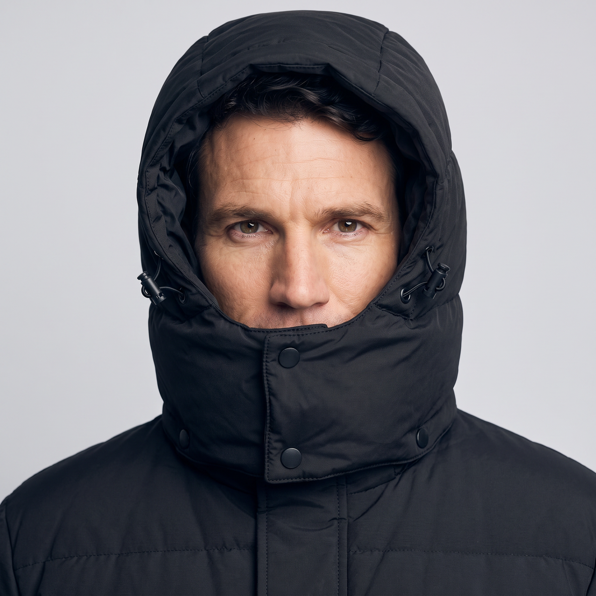 Insulated hood with drawcord toggle drawn in around the face