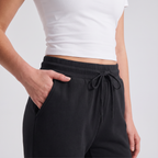 Close-up of the elasticated drawcord waistband and side pocket of the black joggers
