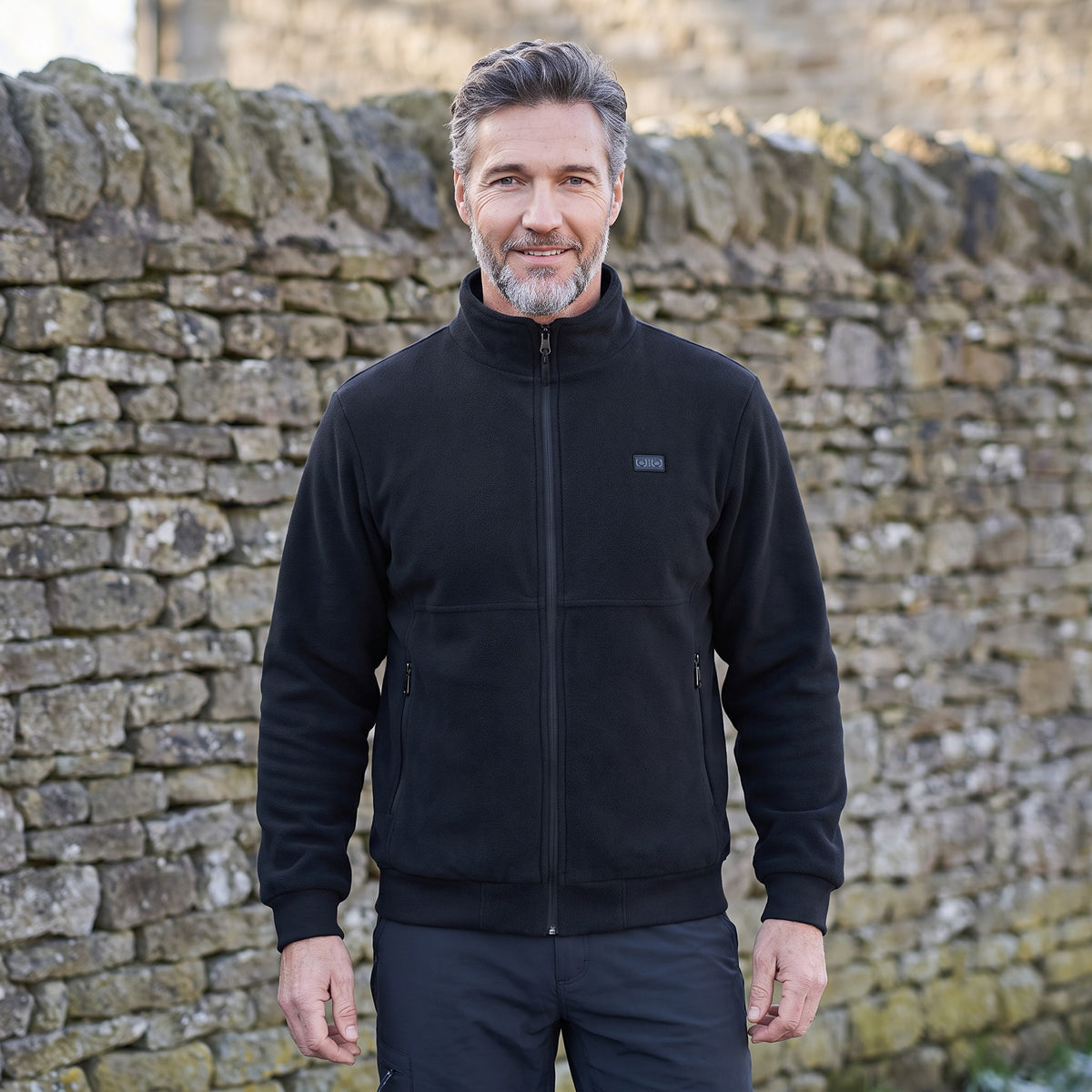 Heated jacket worn by a man, front view, zipped up with stand collar