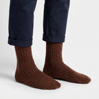 Brown wool socks worn by a man, rolled navy chinos