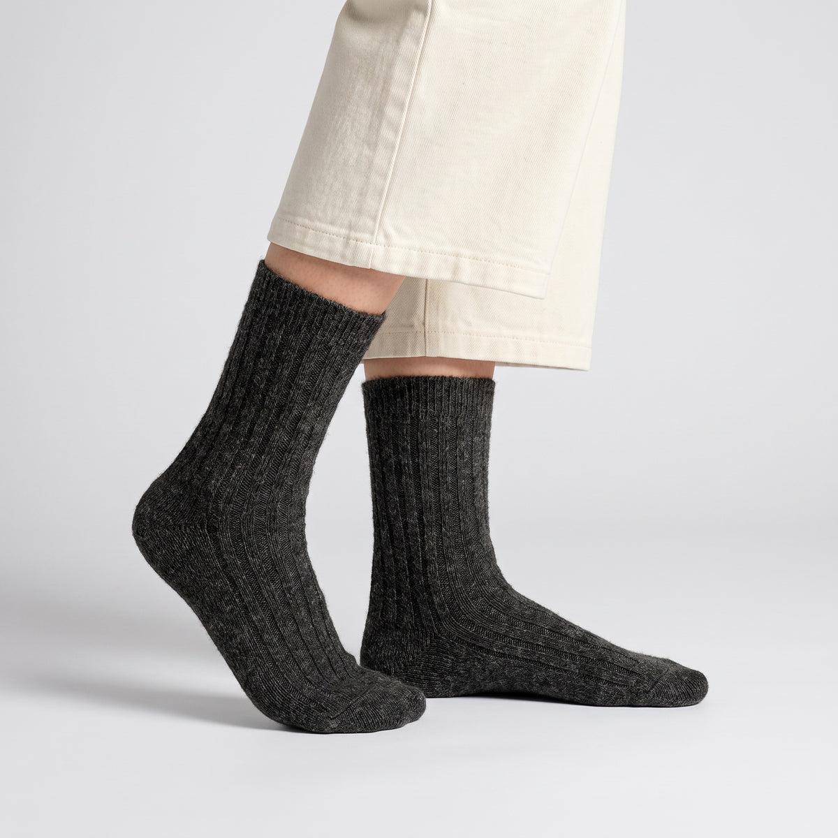 Charcoal wool socks worn by a woman