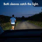Driver's view at dusk of a runner whose reflective sleeve strips catch the headlights