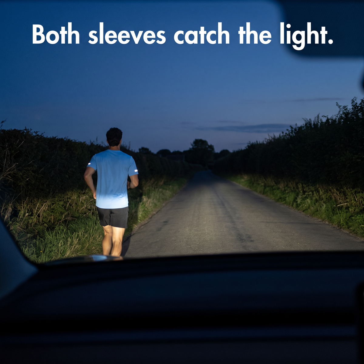 Driver's view at dusk of a runner whose reflective sleeve strips catch the headlights