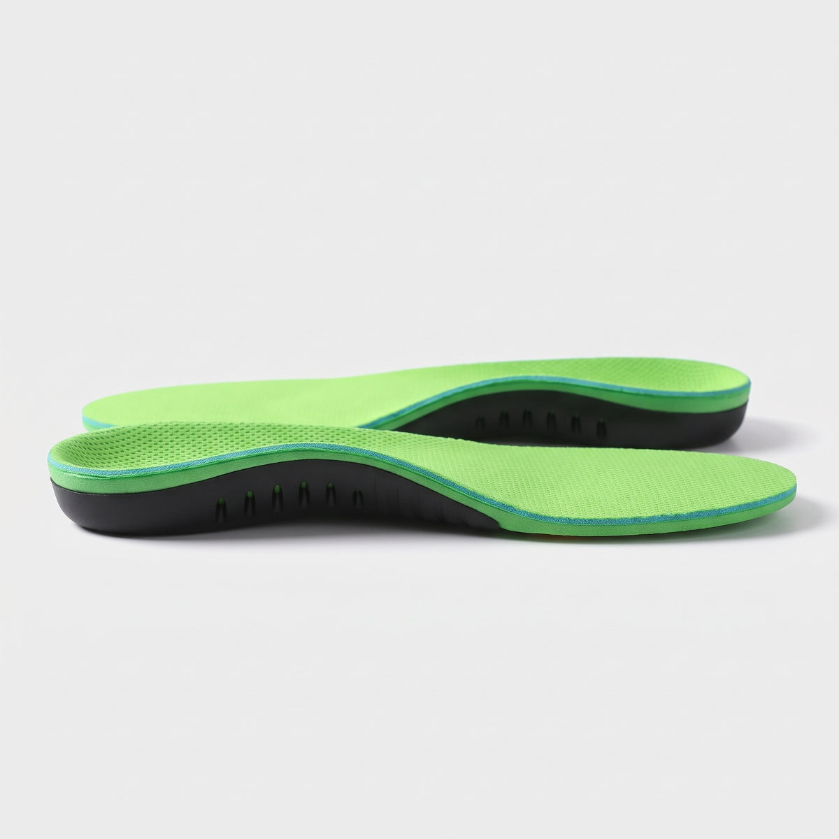Side view of the green arch support insole showing the raised arch shell, vent slots and heel cup