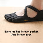 Close-up of a black five toe shoe on a cork yoga mat, each toe pocket gripping on its own