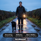 Man walking a dog on a dark lane, the reflective bands on his wellies lit by car headlights