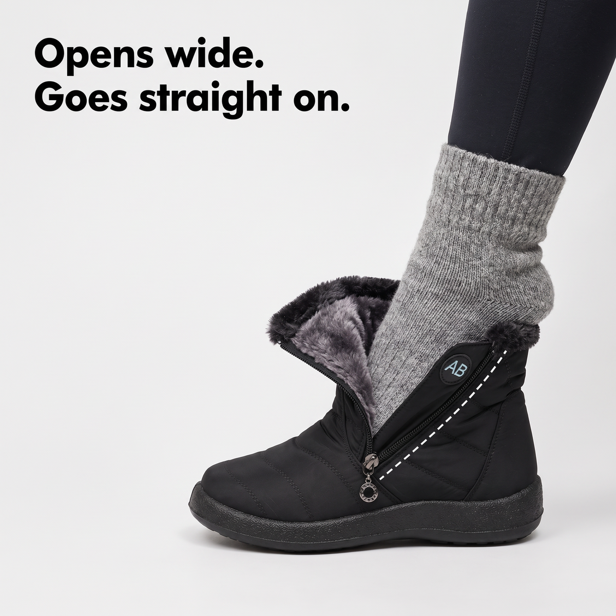 A foot in a wool sock stepping into a winter boot with its side zip fully open