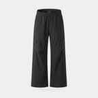 Women's wide leg walking trousers in black, front view, showing the elasticated drawcord waist and two diagonal zip thigh pockets