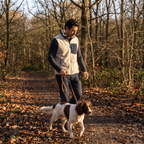 Man wearing the sherpa fleece gilet walking a dog on a woodland path