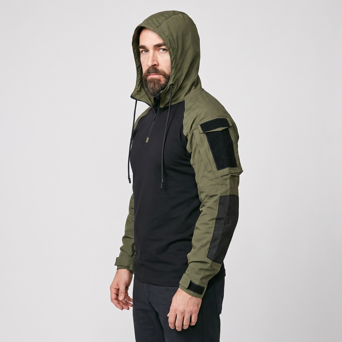 Green tactical hoodie worn with the drawcord hood up, side view