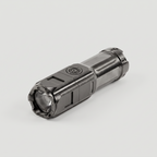 Small rechargeable torch at an angle showing the power button and zoom head