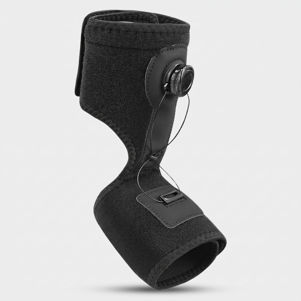 Adjustable night splint with a rotary dial and steel cable, three-quarter view on a light grey background