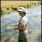 Angler wearing the sun hat with neck flap while fly fishing in a sunny chalk stream