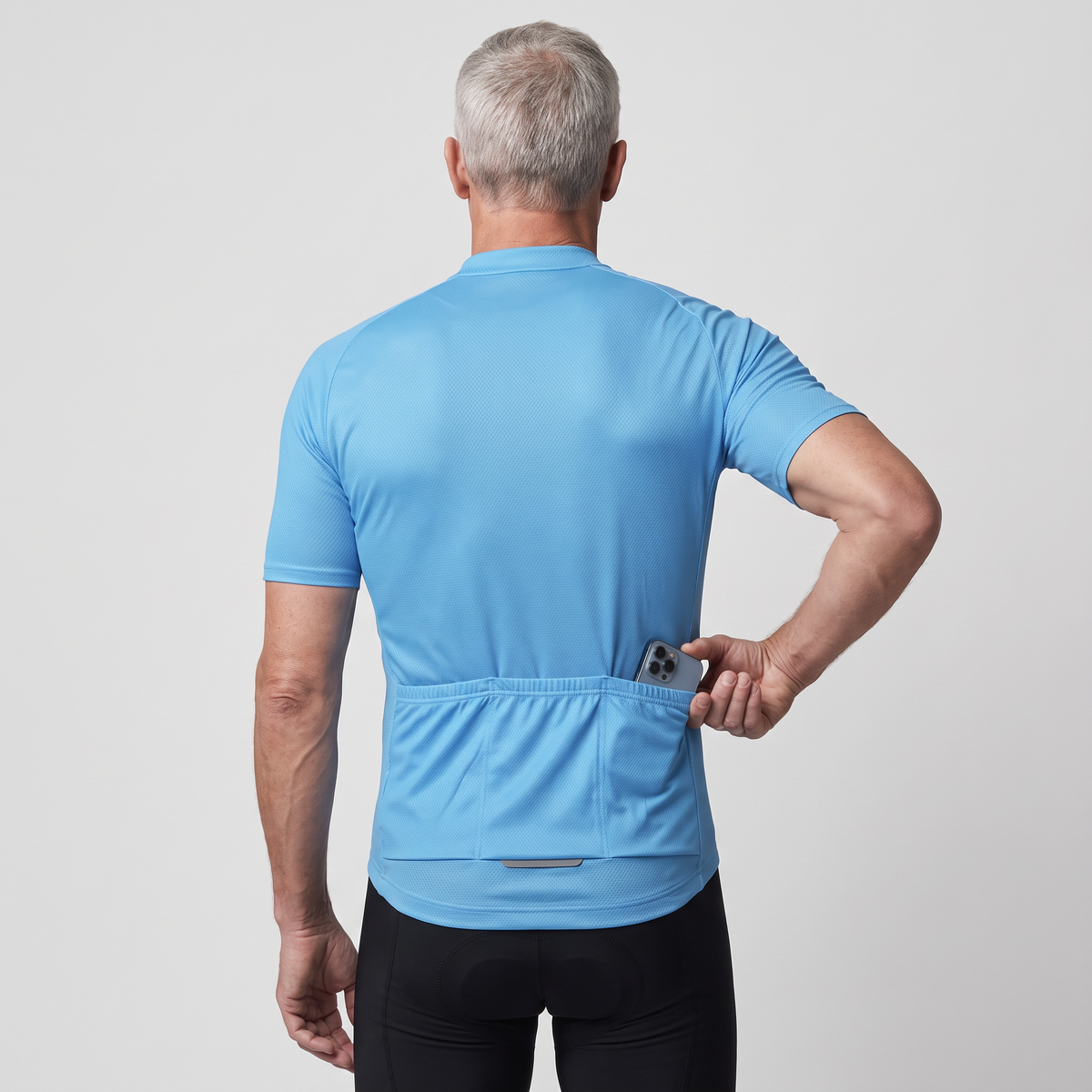 Man seen from behind sliding a phone into the rear jersey pocket
