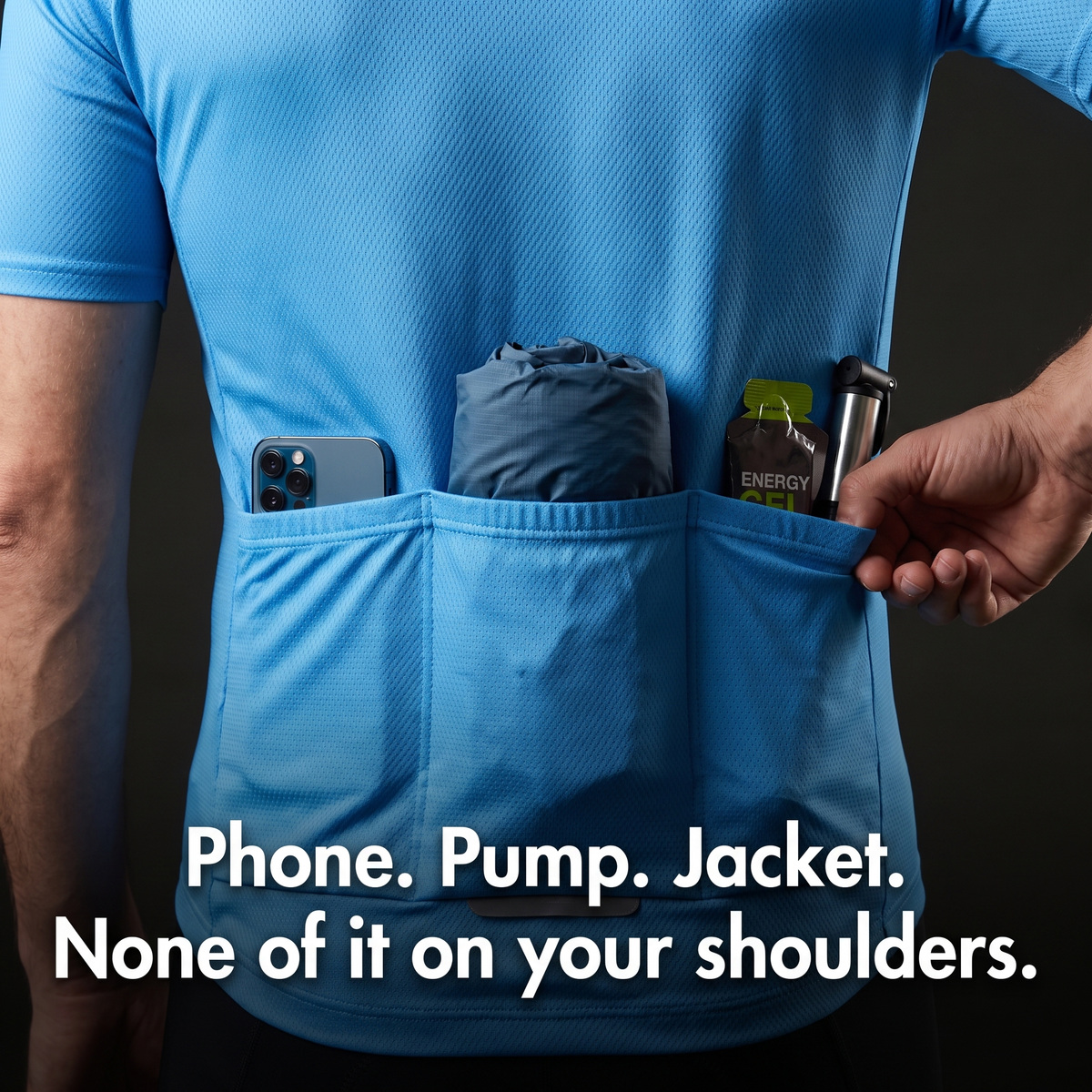 Rider's hand reaching into a loaded rear pocket: phone, packed jacket, energy gel and pump