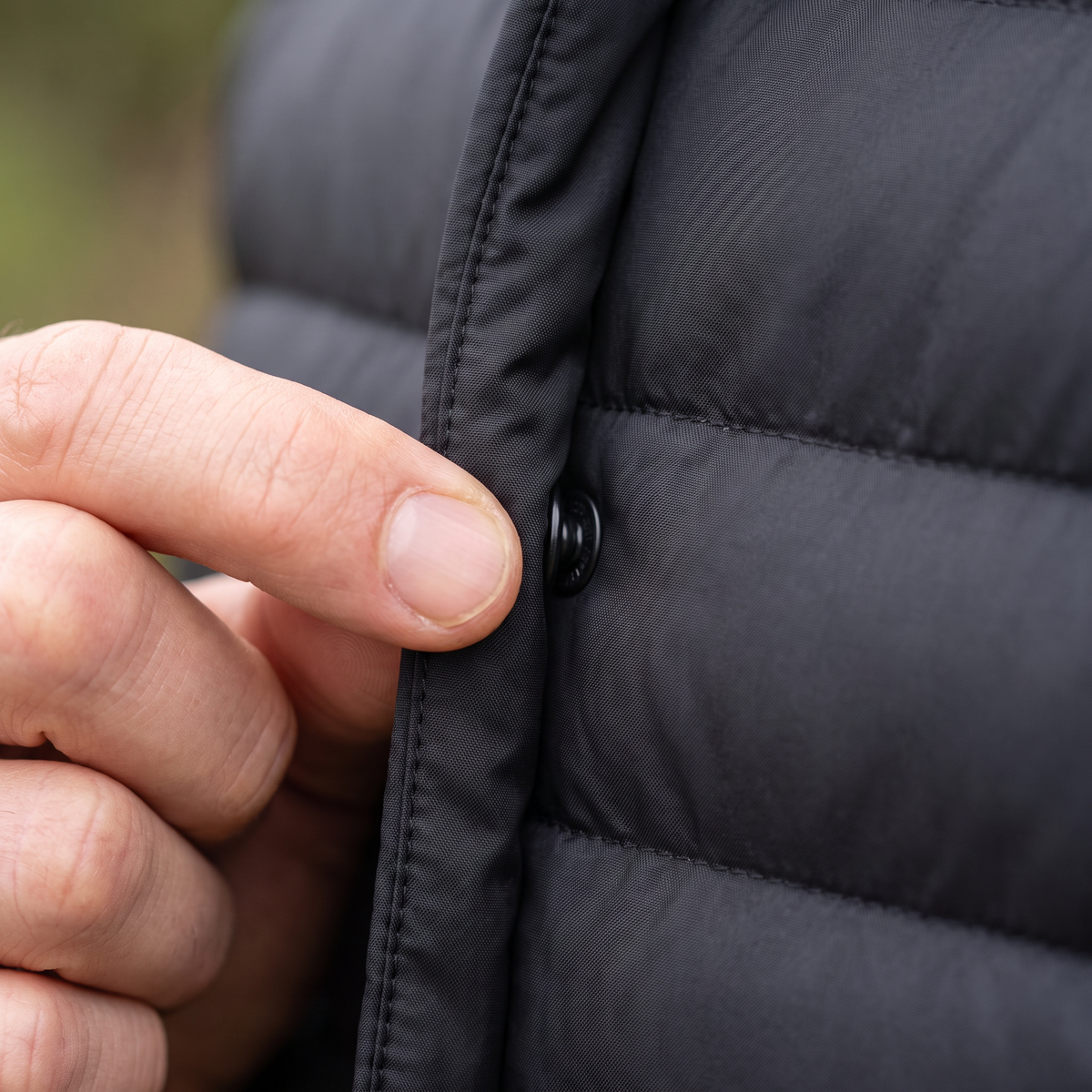 Close-up of a tone-on-tone snap popper being done up on the Terrabound Men's Down Jacket