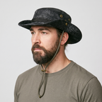 Man wearing the Terrabound men's boonie hat in black python print, three-quarter view showing the vent eyelets