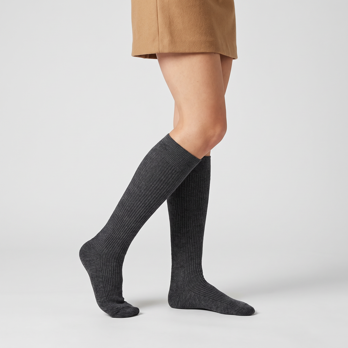 Woman wearing charcoal merino wool knee high socks with a skirt