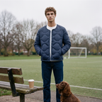Man at a park football pitch wearing the Terrabound Men's Puffer Jacket in Navy