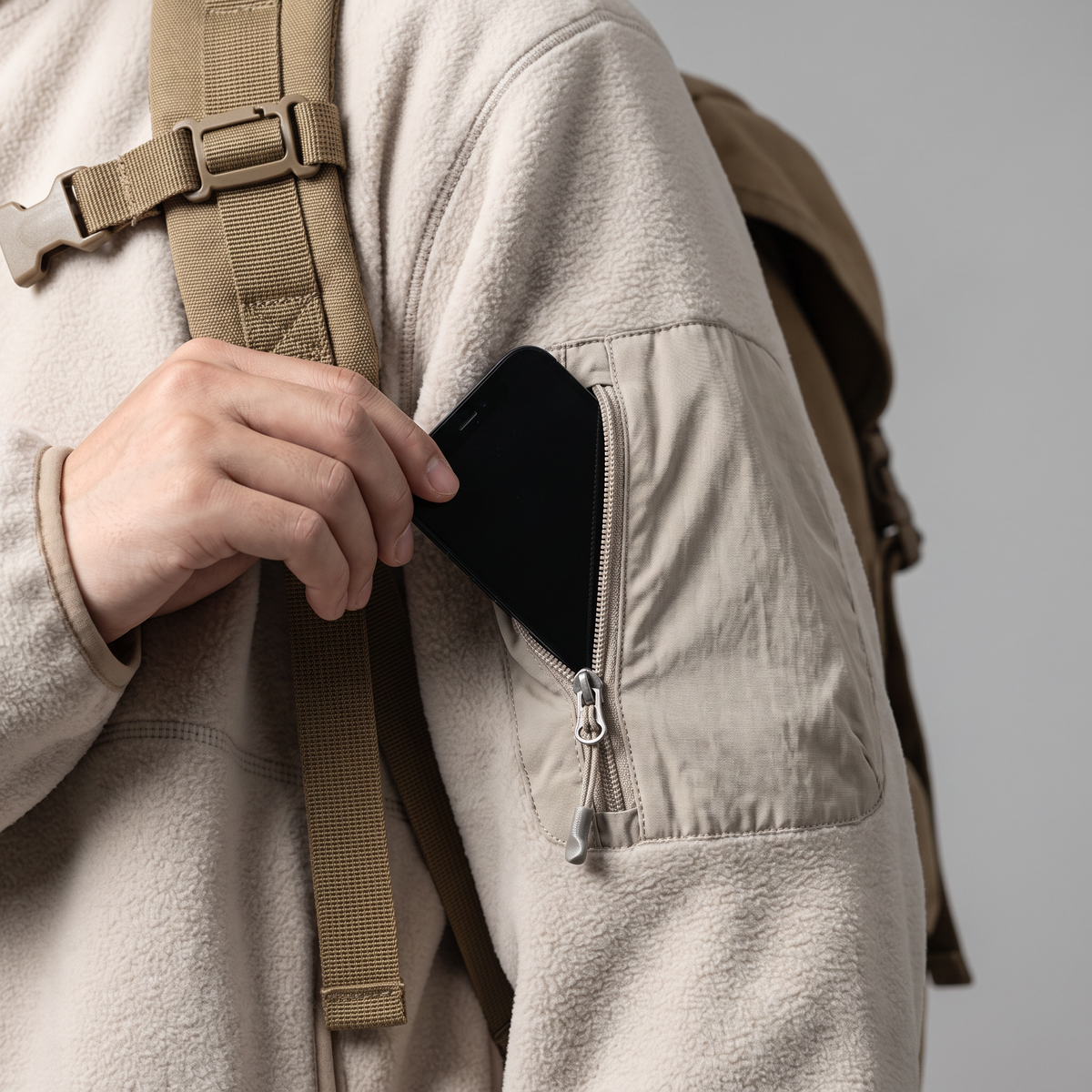 Zipped bellows pocket on the upper left sleeve with a rucksack strap