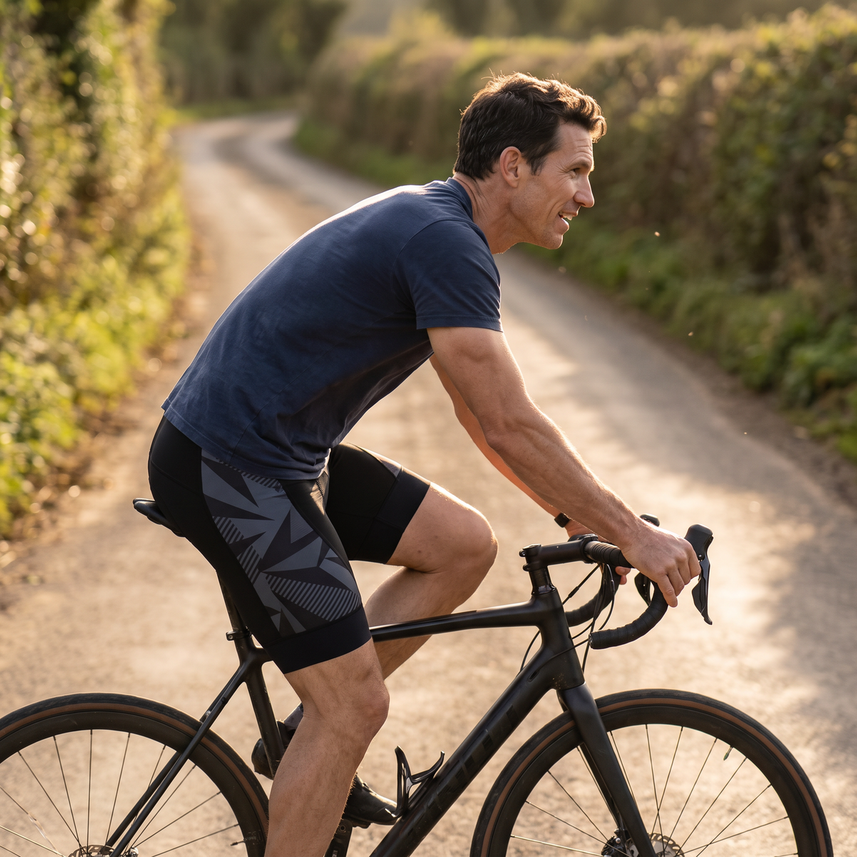 Cyclist riding a country lane at golden hour in the cycling shorts