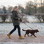 Woman walking a dog on a frosty park path wearing Terrabound Women's Walking Boots in Wheat