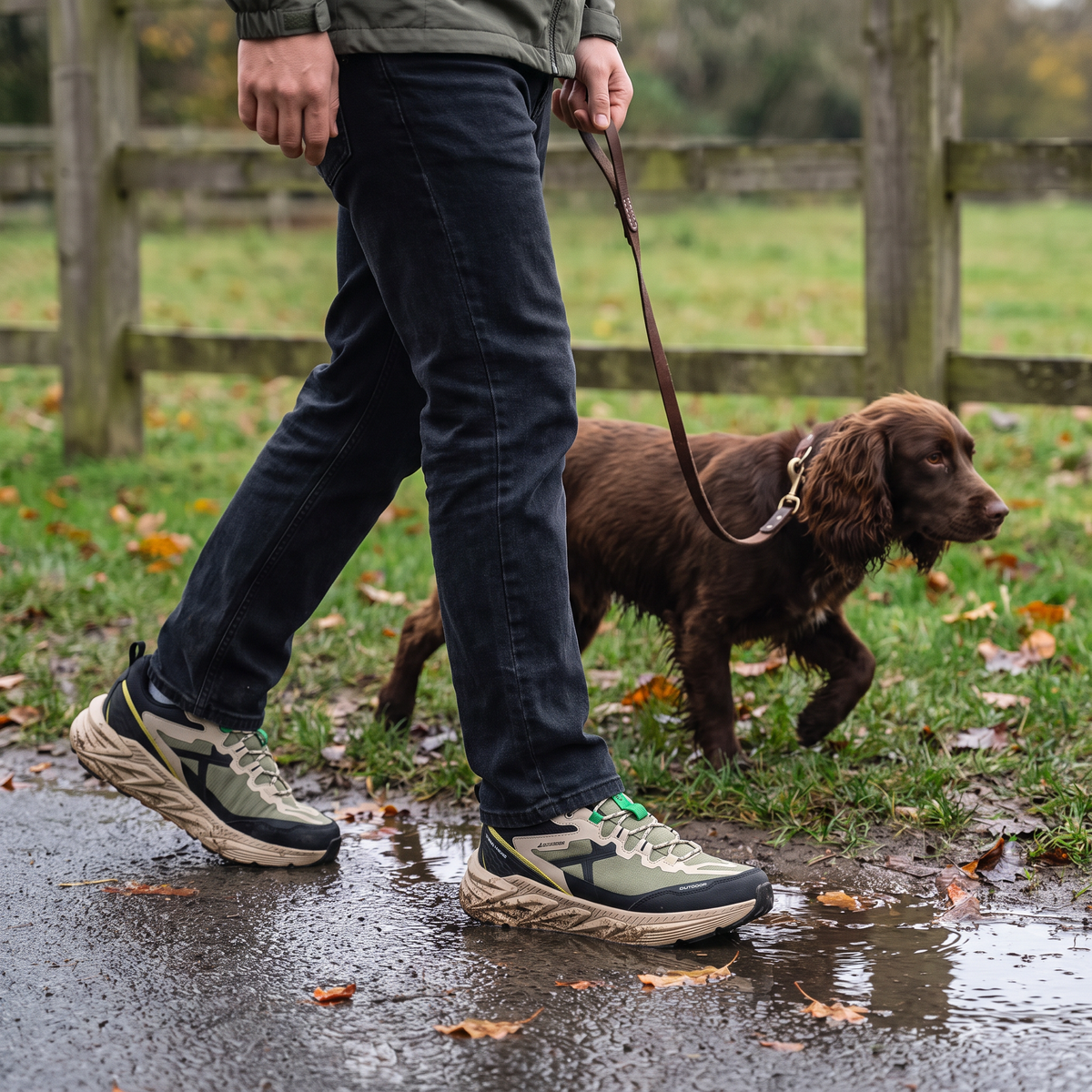 Man walking a spaniel on a wet park path wearing Terrabound Men's Trail Shoes in Olive