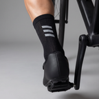 Cycling sock worn in a road cycling shoe on a pedal, seen from behind