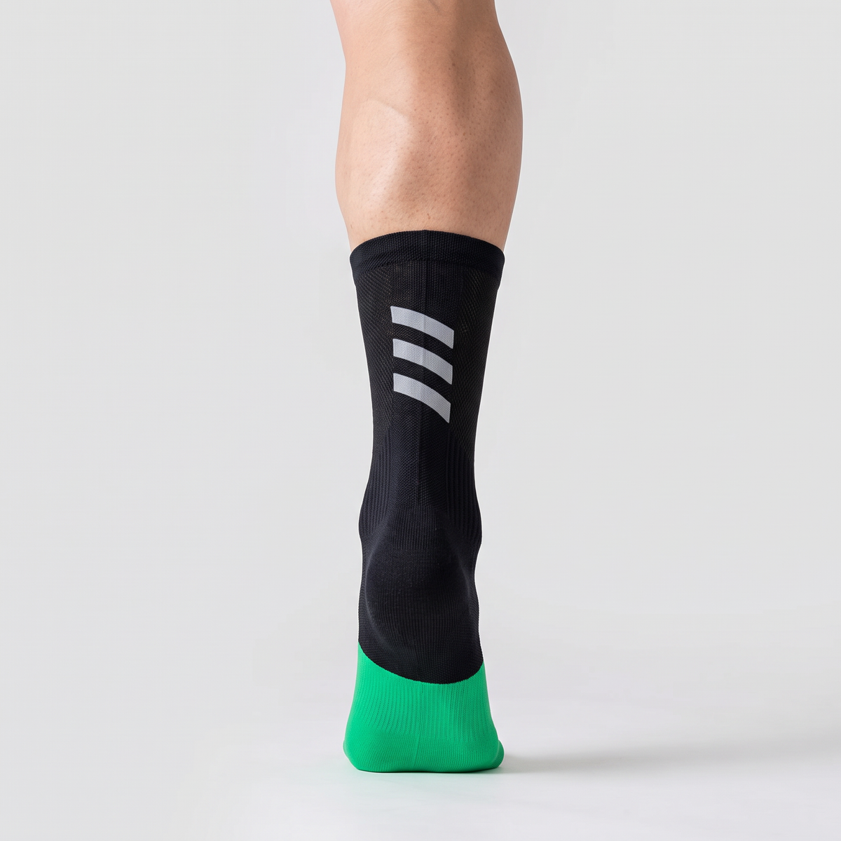 Cycling sock seen from behind, showing the mid-crew height and the reflective bars above the heel