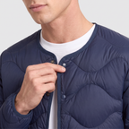 Close-up of the taped collarless neck and top popper of the Men's Puffer Jacket in Navy