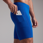 Hand drawing a smartphone out of the open drop-in pocket on the outer thigh, with the perforated vent panel below