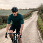 Cyclist riding a country lane in the Dark Green jersey