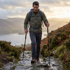 Man walking down a wet Lake District fell path with trekking poles
