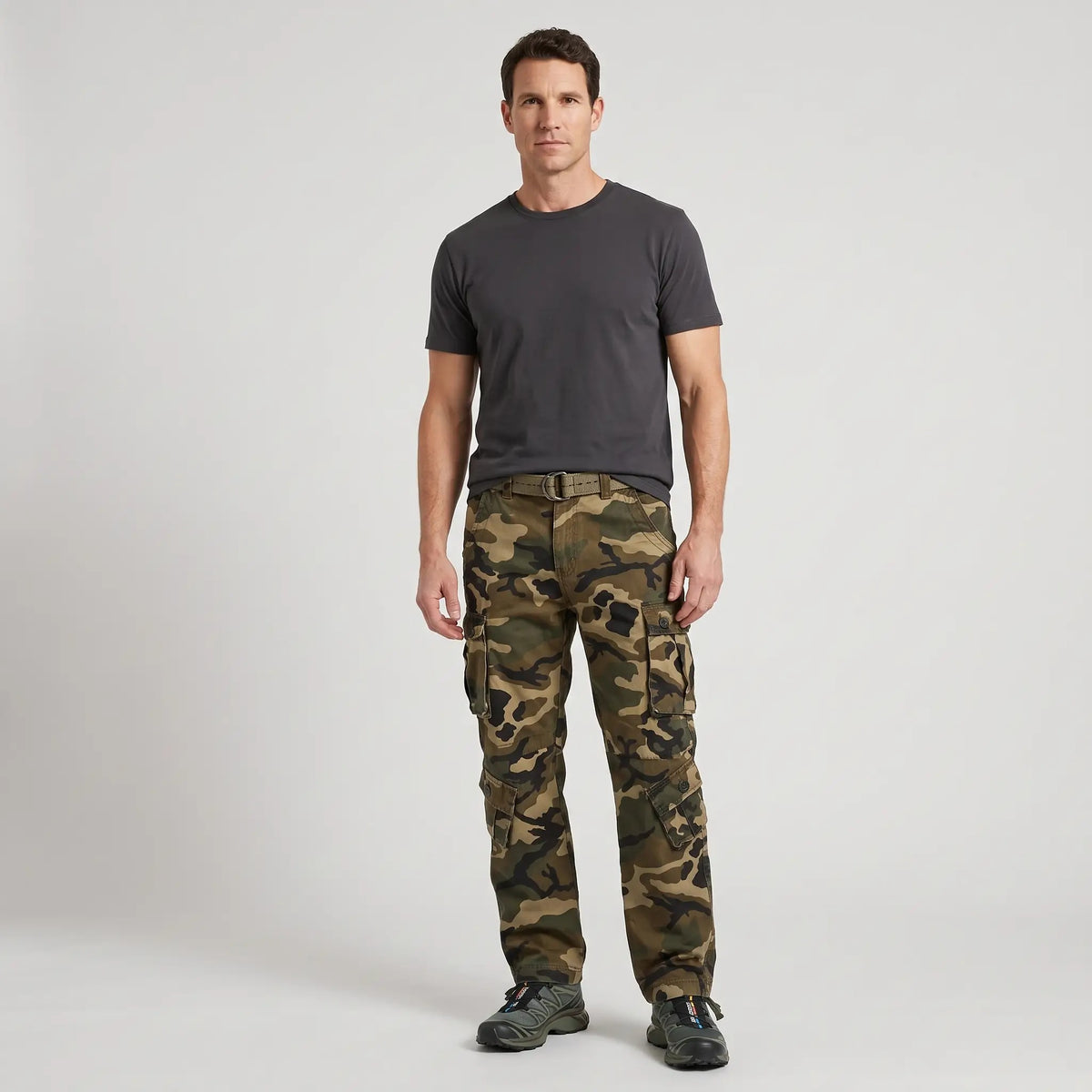 Man wearing Olive Green camo cargo trousers with a charcoal T-shirt and trail shoes