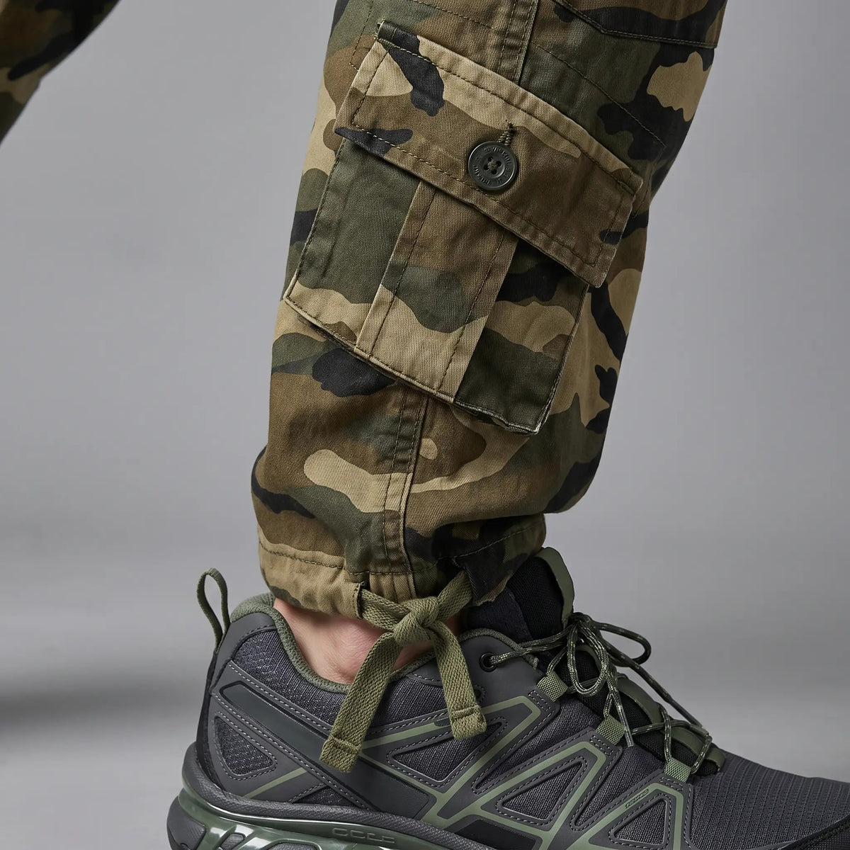 Close-up of the ankle tie cords tied over a trail shoe