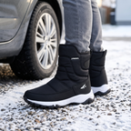 Men's snow boots in Black worn on a snowy driveway