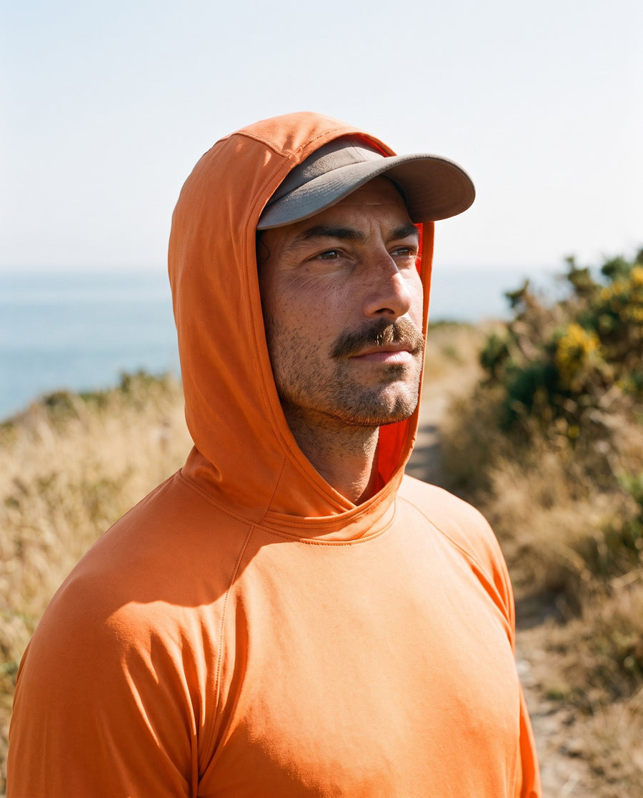 Hood worn up over a cap on the orange sun hoodie