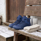 Barefoot winter boots in Navy on a bench beside wool socks and a flask for scale