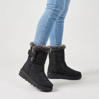 Black fur lined winter boots worn with jeans