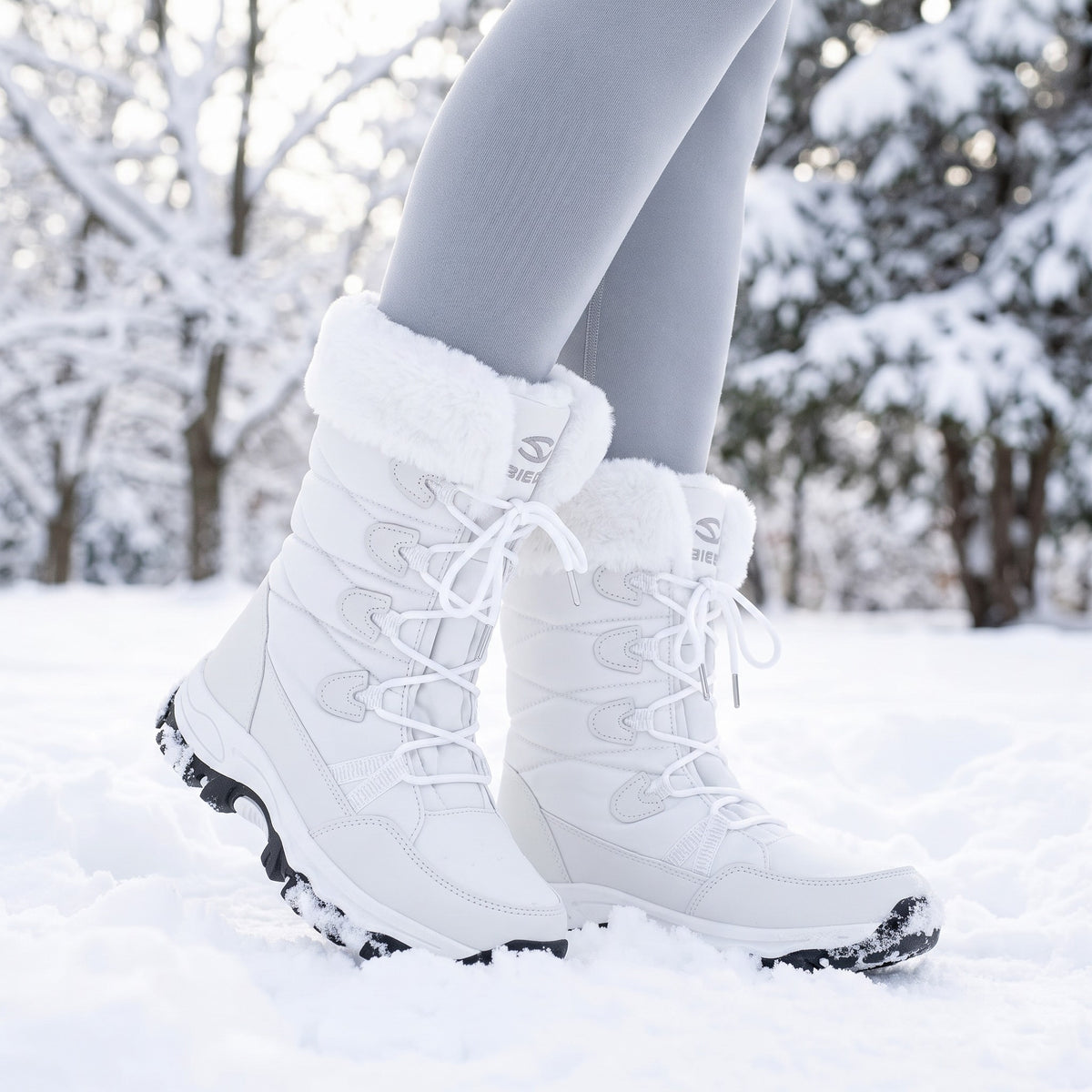 White faux fur snow boots worn in fresh snow in a park