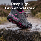 Deep lug rubber sole of the women's hiking shoes gripping a wet rock step