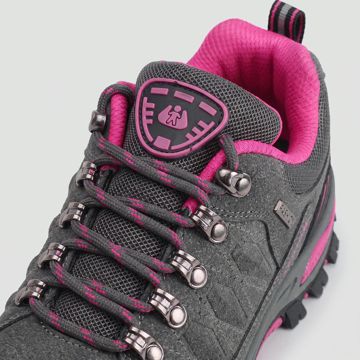 Close-up of the metal lace hooks, padded tongue badge and collar on the Grey hiking shoes