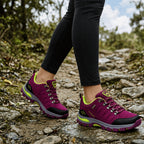 Purple women's walking shoes worn on a rocky trail