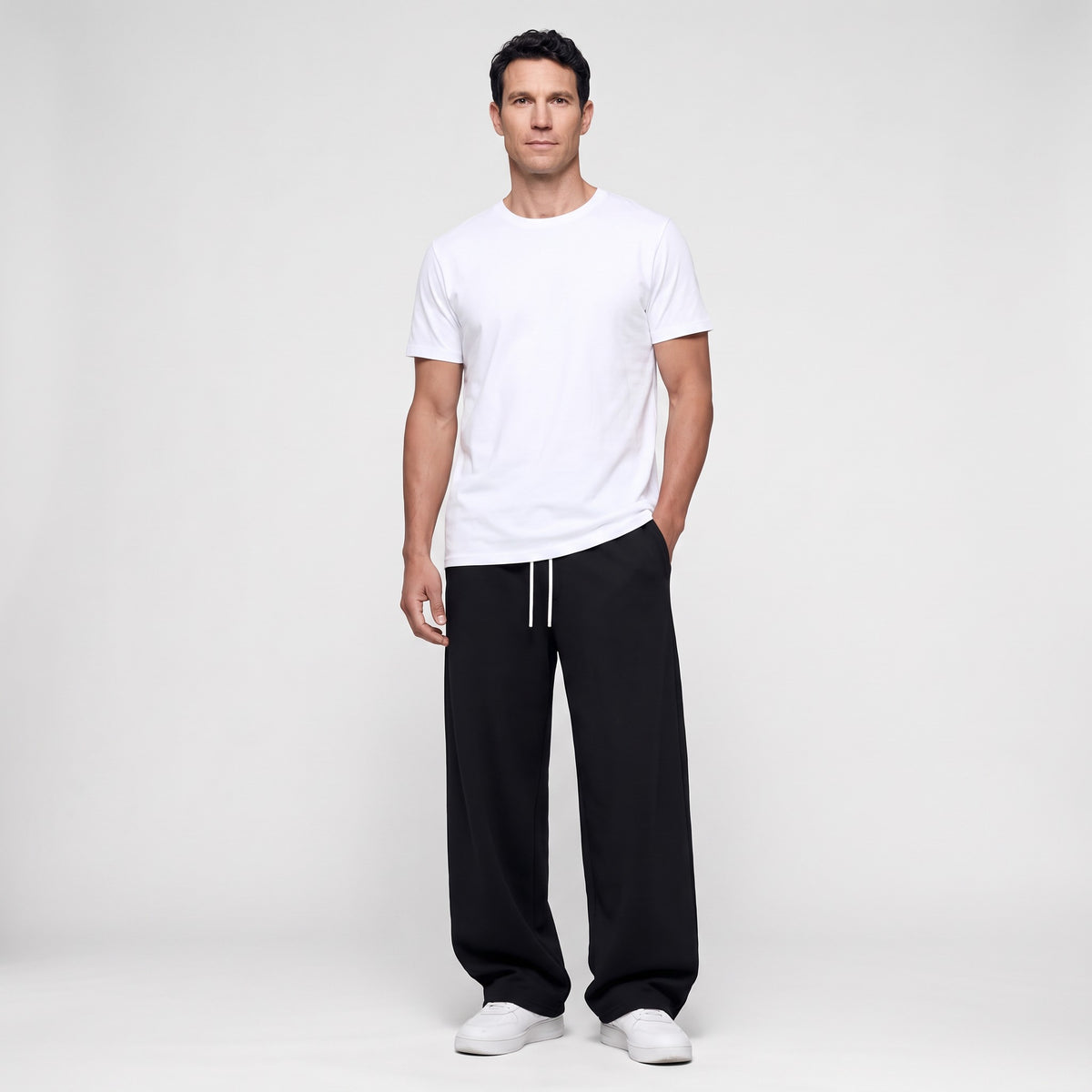 Man wearing the Black men's joggers with a white t-shirt, full length front view