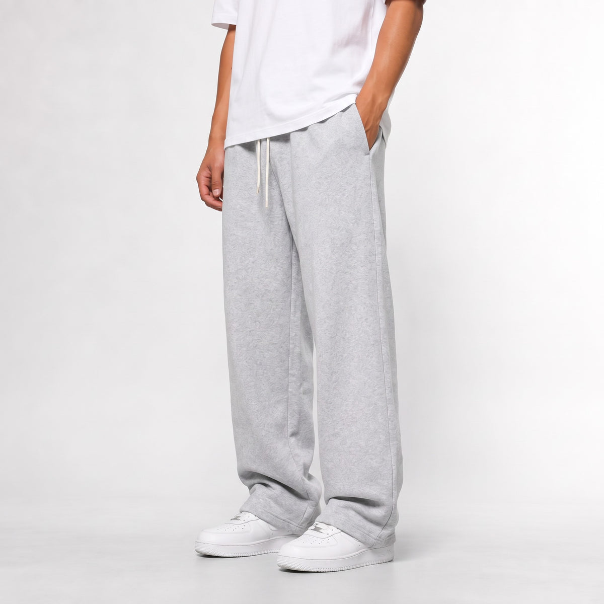 Light Grey baggy straight leg joggers, three-quarter side view with the open hem over white trainers
