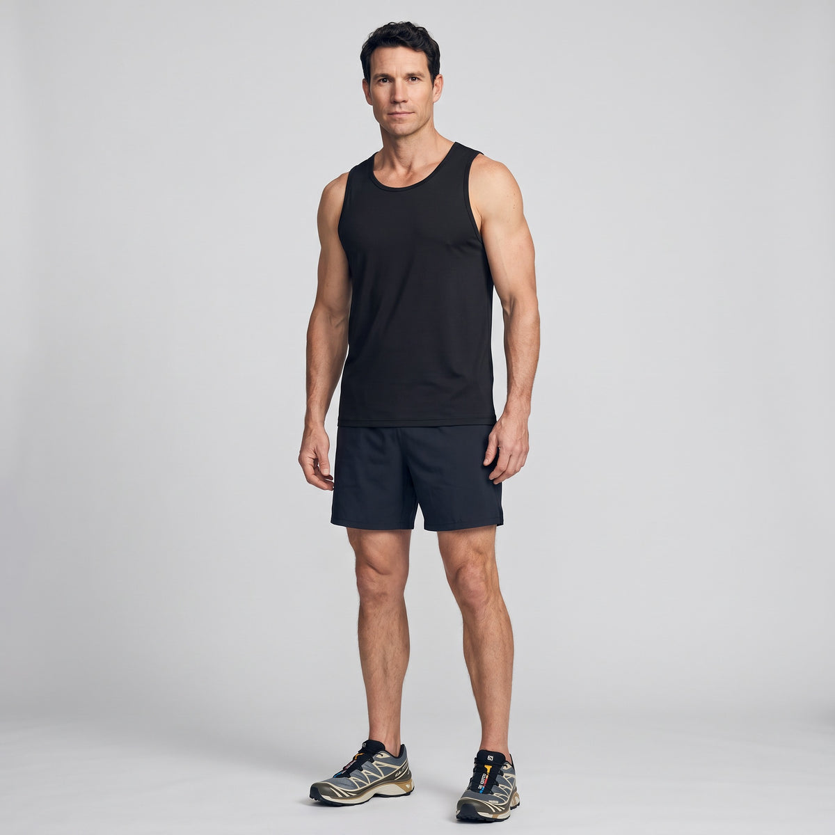 Man wearing the men's running top in Black with running shorts and trail shoes, full length