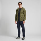 Full-length view of a man wearing the zip up hoodie with dark trousers